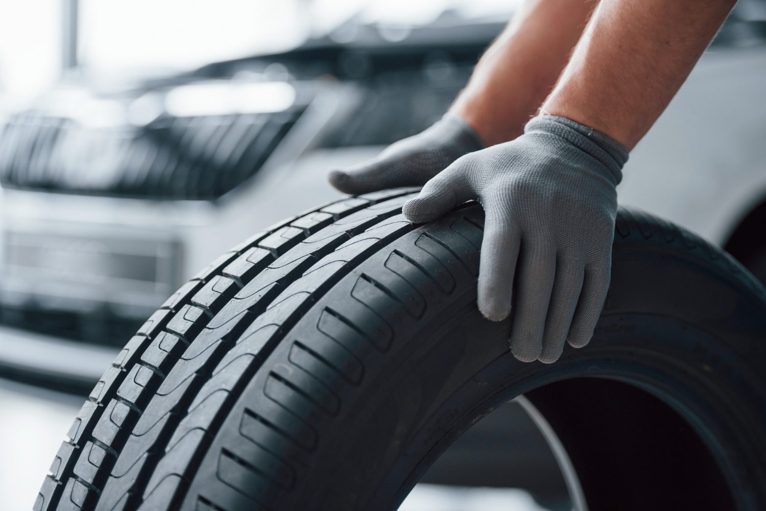 hands-only-mechanic-holding-tire-repair-garage-replacement-winter-summer-tires hands-only-mechanic-holding-tire-repair-garage-replacement-winter-summer-tires