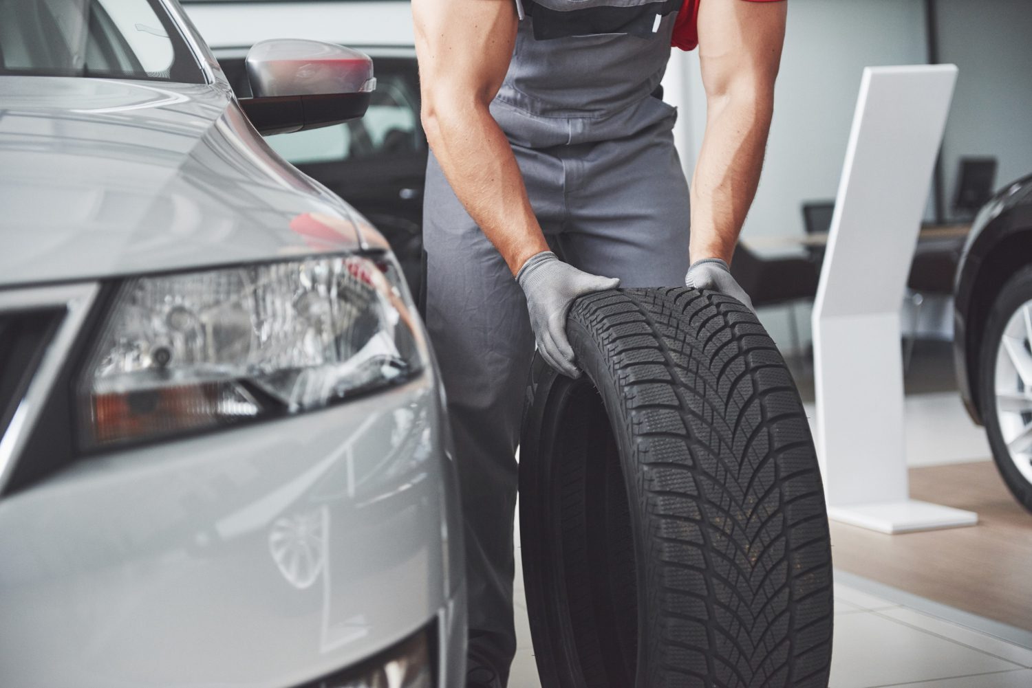 mechanic-holding-tire-tire-repair-garage-replacement-winter-summer-tires Auto & Tire